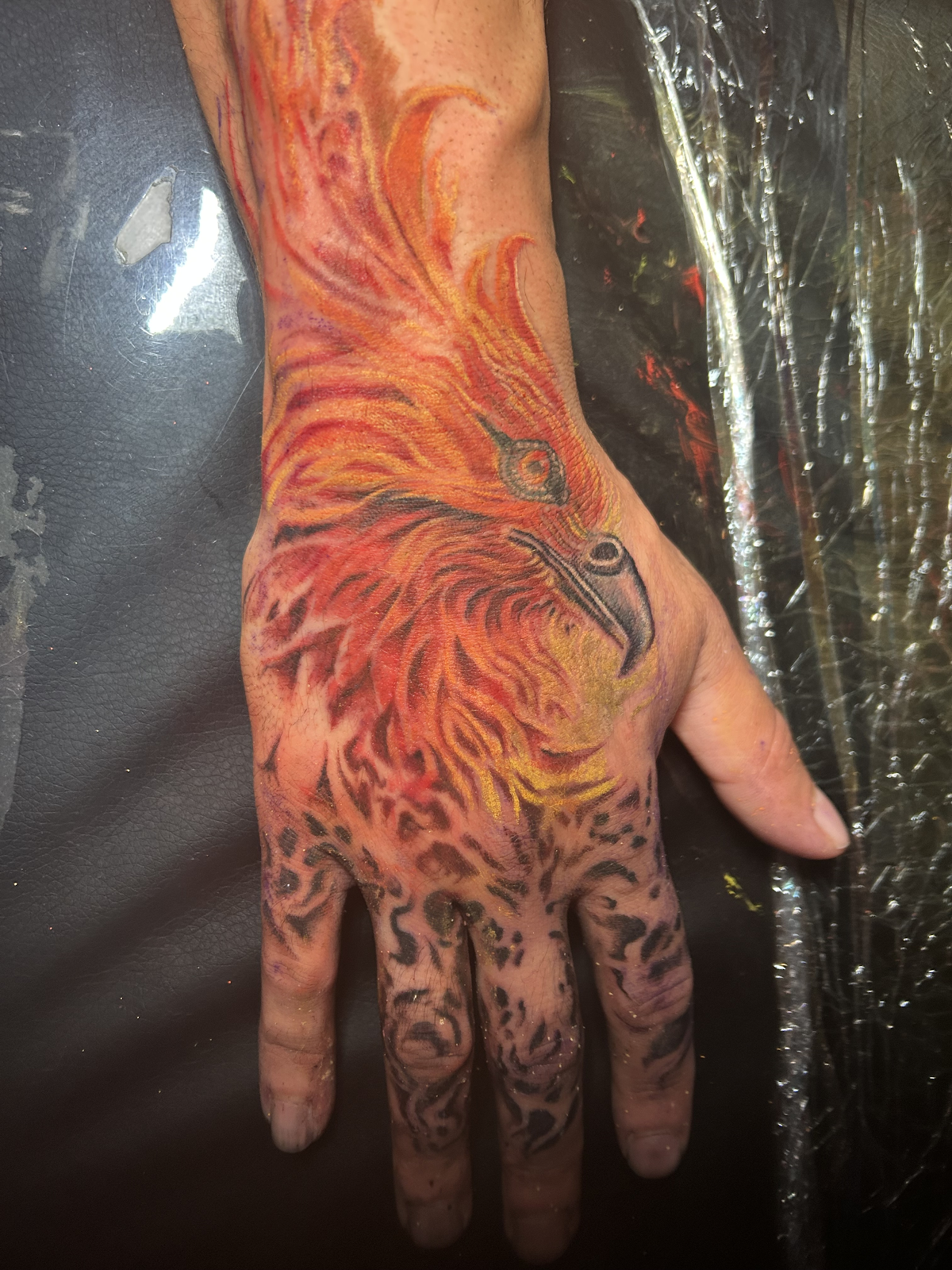 Color phoenix hand tattoo — cover-up and integration work, Work of Art Las Vegas, Work of Art Tattoo & Piercing, Las Vegas