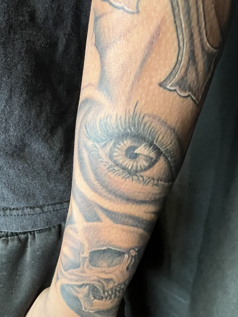 Healed one year realistic eye and skull black and grey forearm tattoo by Joshua Cole, Work of…, Work of Art Tattoo & Piercing, Las Vegas