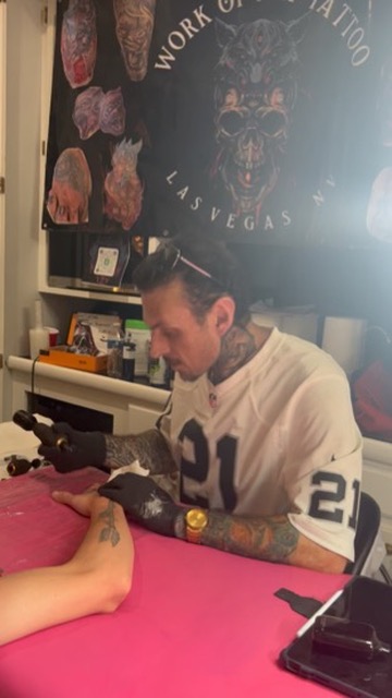Joshua Cole tattoos black-grey rose on forearm beneath Work of Art Las Vegas banner — Joshua…, Work of Art Tattoo & Piercing, Las Vegas