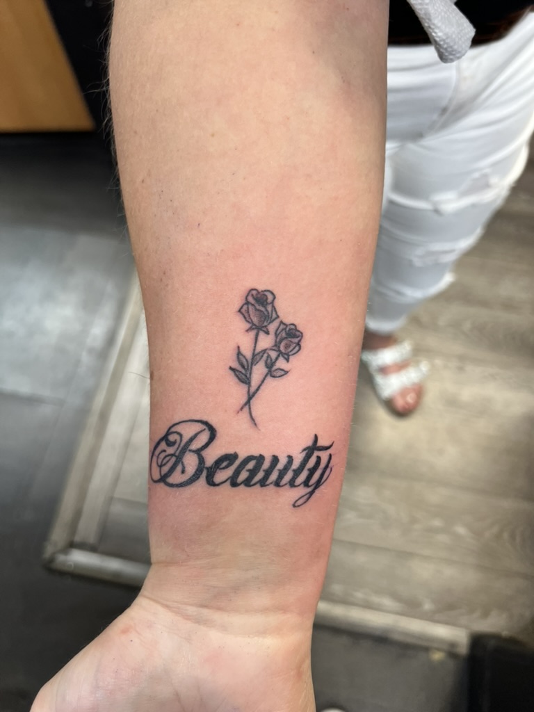 Cursive Beauty script with crossed rose stems on inner forearm. — Joshua Cole, Work of Art Las…, Work of Art Tattoo & Piercing, Las Vegas