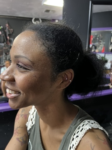 Smiling client showing fresh conch and lobe studs beside colorful butterfly shoulder tattoos…, Work of Art Tattoo & Piercing, Las Vegas