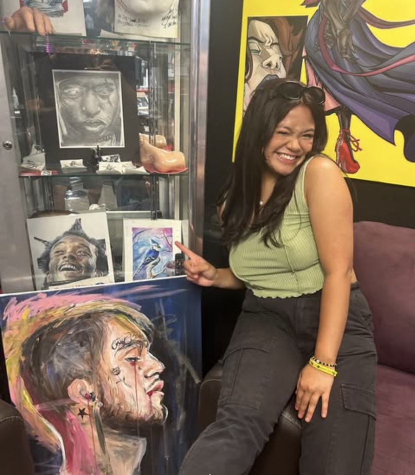 Guest admiring framed portrait art in the Work of Art studio gallery. — Joshua Cole, Work of Art…, Work of Art Tattoo & Piercing, Las Vegas