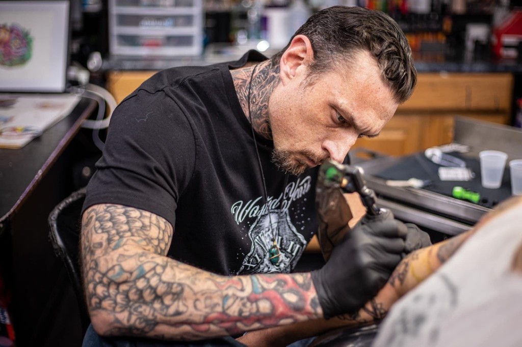 Joshua Cole tattooing a client's forearm with focused detail in the studio. — Joshua Cole, Work…, Work of Art Tattoo & Piercing, Las Vegas