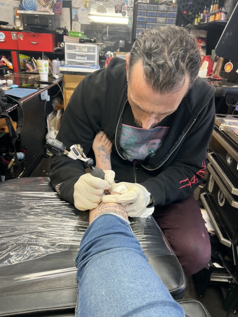 Joshua Cole tattooing illustrative demon and text piece — Work of Art Las Vegas studio, Work of Art Tattoo & Piercing, Las Vegas