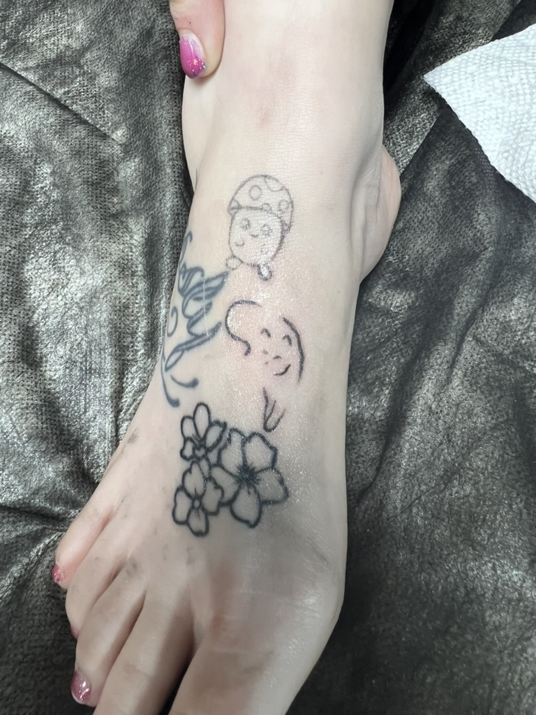 Whimsical mushroom, ghost, and cherry blossom fine-line foot tattoos. — Joshua Cole, Work of Art…, Work of Art Tattoo & Piercing, Las Vegas