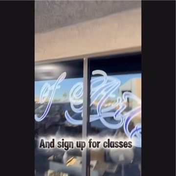 Glass storefront cursive of Art lettering looking out to parking lot, sign up for classes…, Work of Art Tattoo & Piercing, Las Vegas