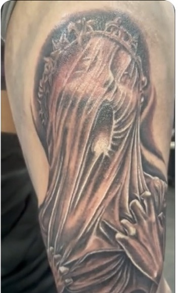 Black-grey veiled woman with ornate crown clutching fabric on upper arm, halo backdrop — Joshua…, Work of Art Tattoo & Piercing, Las Vegas